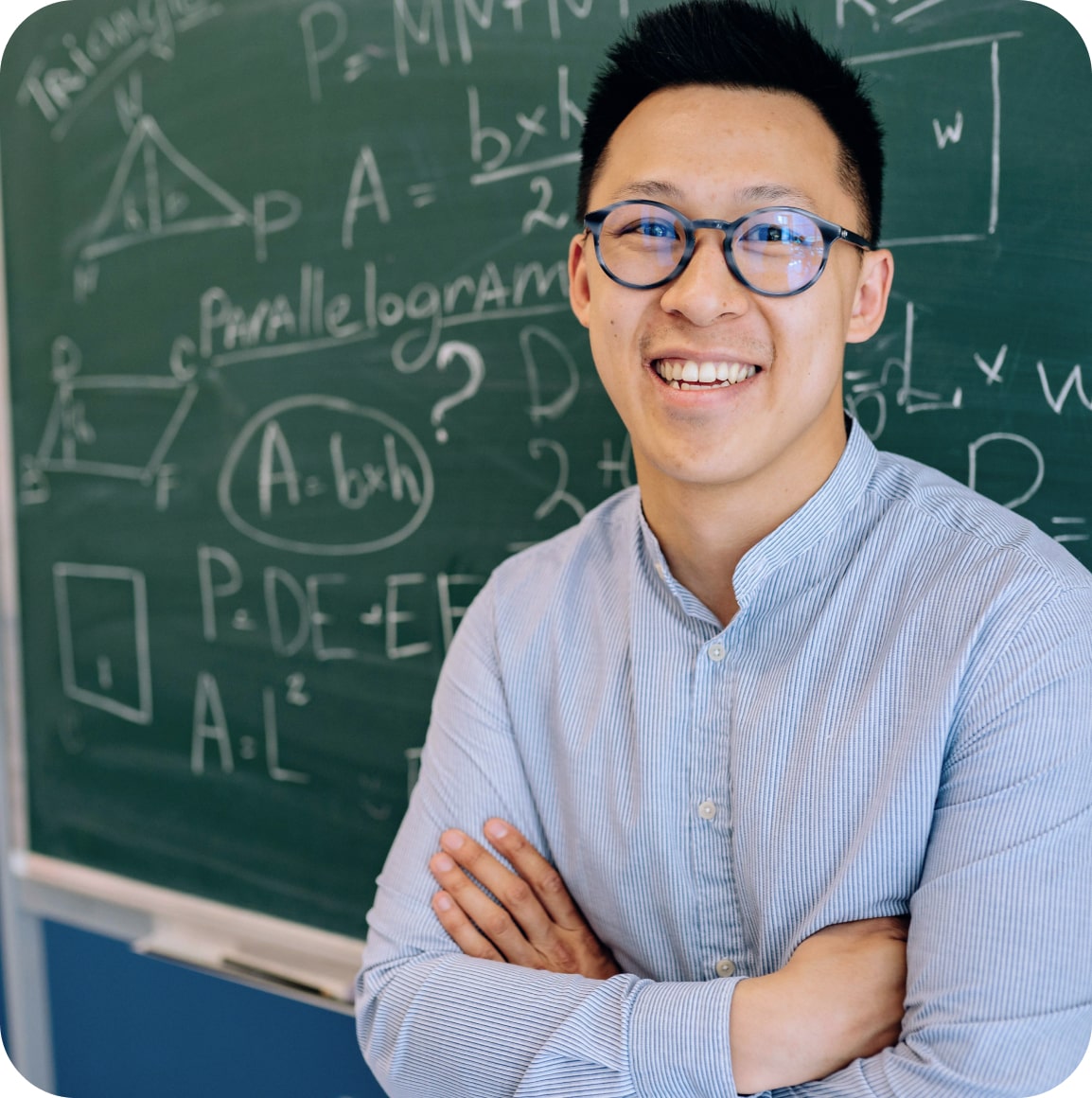 Professeur de mathématiques souriant devant un tableau rempli de formules, prêt à enseigner